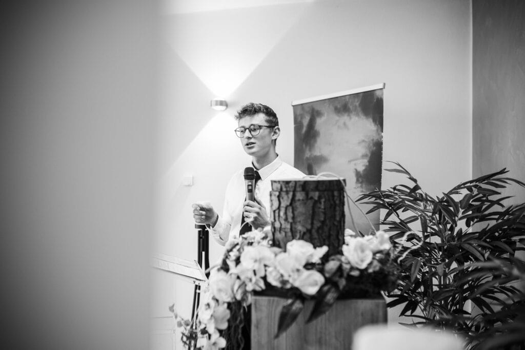 Redner bei Ausbildung in Österreich mit Blumen und Mikrofon.